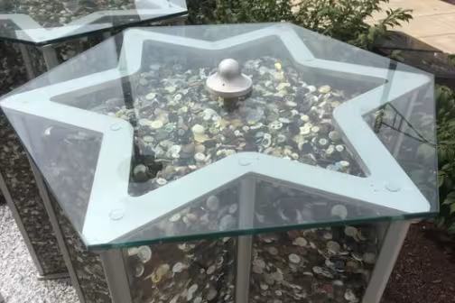 Glass container in the shape of a star of David full of buttons